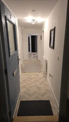 a hallway with a door and a hallway with a rug at 3,Lime Tree Ave in Moffat