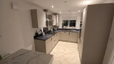 a large kitchen with white cabinets and a window at 3,Lime Tree Ave in Moffat