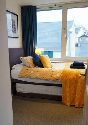 a bed in a room with a large window at Coppet Cove - 2 Bedroom Apartment - Saundersfoot in Moffat