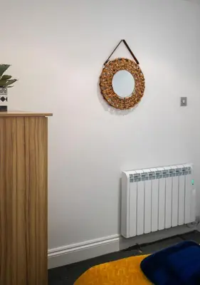 a wreath hanging on a wall next to a radiator at Coppet Cove - 2 Bedroom Apartment - Saundersfoot in Moffat