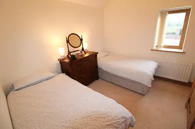 a bedroom with two beds and a mirror on a dresser at Mindrum, Skelton a spacious and characterful house close to Penrith & Ullswater in Skelton