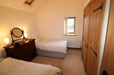 a bedroom with two beds and a mirror and a dresser at Mindrum, Skelton a spacious and characterful house close to Penrith & Ullswater in Skelton