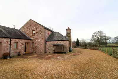 an old stone house with a grill in the yard at Mindrum, Skelton a spacious and characterful house close to Penrith & Ullswater in Skelton