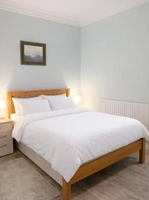 a bedroom with a large bed with white sheets at The Manor House in Peel