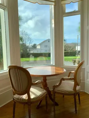 a table and two chairs in front of a window at The Manor House in Peel