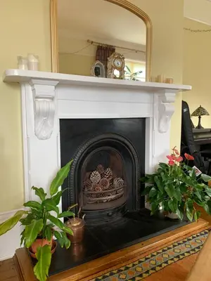 a fireplace with a mirror on top of it at The Manor House in Peel