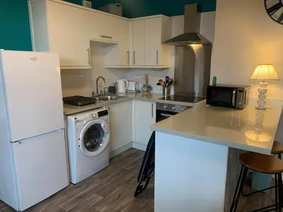 a kitchen with a white refrigerator and a dishwasher at The Manor House in Peel