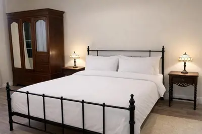 a bedroom with a large white bed with two lamps at The Manor House in Peel