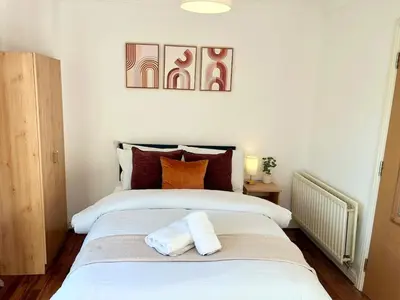 a bedroom with a large white bed with two pillows at 3-Bedroom house near Manchester City Centre in Moffat