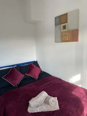 a bed with a purple blanket with a towel on it at Brisco Terrace-sleeps 6 in Woodend