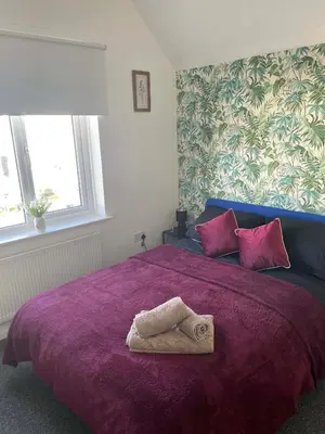 a bedroom with a purple bed with a towel on it at Brisco Terrace-sleeps 6 in Woodend