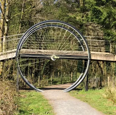 a bicycle wheel on a bridge over a path at Barnharrow Holiday Park in Newton Stewart