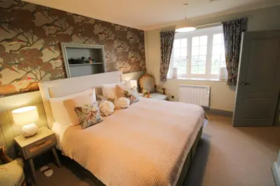 a bedroom with a large bed and a window at Drakes Rest, Kirklinton with hot tub, ideal romantic escape in Kirklinton