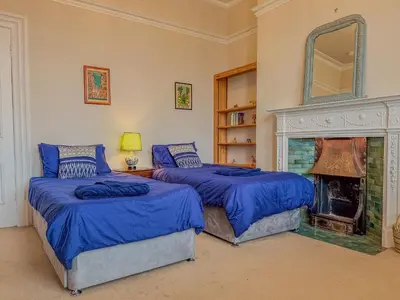 two beds in a room with a fireplace at Eden Mount, Wetheral, characteful, spacious home overlooking village green, close to M6 in Wetheral