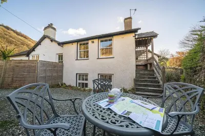 a table and chairs in front of a house at Ben Place Cottage - Grasmere in Grasmere