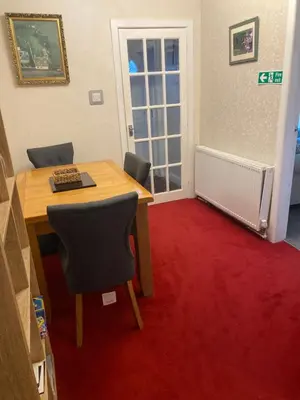 a room with a table and chairs and a red carpet at Gramhor House in Dumfries