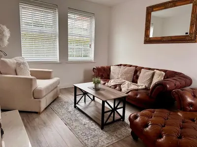 a living room with a leather couch and a table at Modern 3 Bedroom Home in Egremont, Western Lake District, Sleeps up to 6 in Egremont