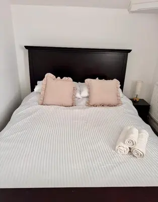 a bed with two pillows and two towels on it at Modern 3 Bedroom Home in Egremont, Western Lake District, Sleeps up to 6 in Egremont