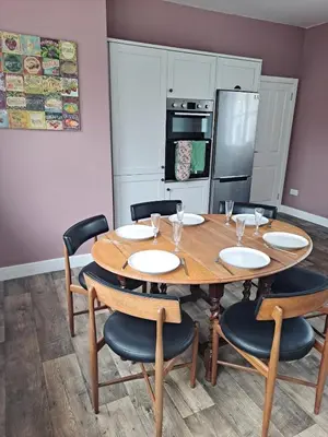 a dining room with a wooden table and chairs at Cosy Cottage in Moffat, South Scotland in Moffat