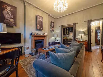 a living room with blue couches and a fireplace at West London Boutique Apartment in Moffat