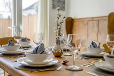 a wooden table with plates and wine glasses on it at 3 Bed in Portinscale oc-w31059 in Portinscale