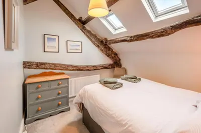 a bedroom with a bed and a dresser and windows at 2 Bed in Dean oc-h32066 in Dean