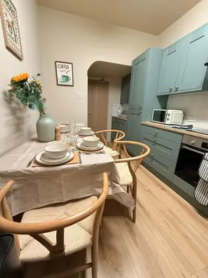 a kitchen with a table and chairs and a kitchen with blue cabinets at Contractor 4BD Carlisle Long Stay w Wi-Fi, Washer, Smart TVs & Parking in Carlisle