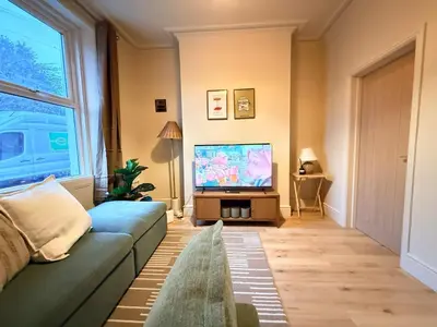 a living room with a couch and a flat screen tv at Contractor 4BD Carlisle Long Stay w Wi-Fi, Washer, Smart TVs & Parking in Carlisle