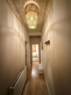 a hallway with a chandelier on the ceiling and a hallway with a staircase at Contractor 4BD Carlisle Long Stay w Wi-Fi, Washer, Smart TVs & Parking in Carlisle