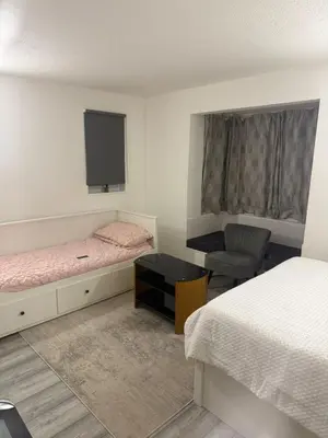 a room with two beds and a tv and a chair at House of Card in Moffat