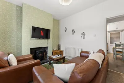 a living room with leather couches and a fireplace at Vintage 2 Bed House in Lamplugh in Lamplugh
