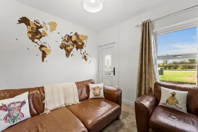 a living room with a leather couch and a world map on the wall at Vintage 2 Bed House in Lamplugh in Lamplugh
