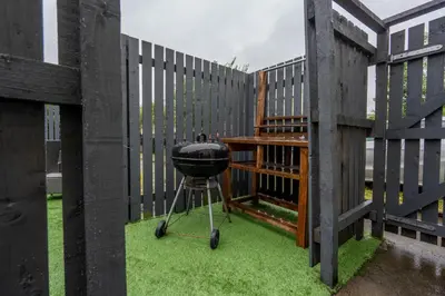 a grill on a stand in front of a fence at Moffat Apartment with Hot Tub in Moffat