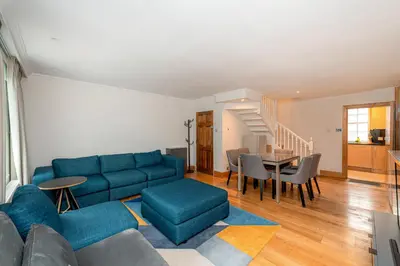 a living room with a blue couch and a table at Knightsbridge Duplex Two Bedroom Apartment in Moffat