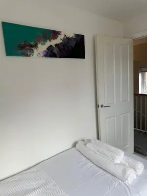 a white bed with two white towels on top of it at Pearl House in Moffat