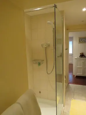 a shower with a glass door in a bathroom at THE WHEEL,Harbour view apartment for two - private front entrance and patio in Moffat