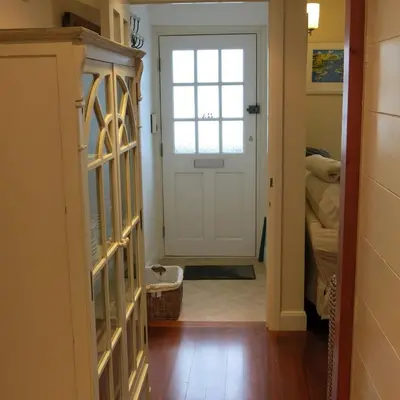 a hallway with a white door with a window at THE WHEEL,Harbour view apartment for two - private front entrance and patio in Moffat
