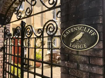 a sign on a gate with a bird on it at Ravenscliffe Lodge in Douglas