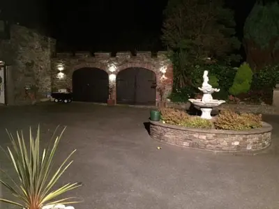 a fountain in the middle of a courtyard at night at Ravenscliffe Lodge in Douglas