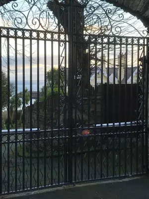 a gate with a view of the ocean behind it at Ravenscliffe Lodge in Douglas