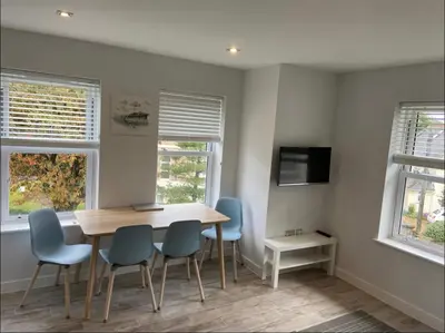 a dining room with a wooden table and blue chairs at The Palms in Moffat