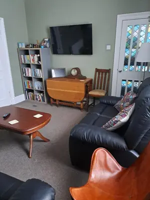 a living room with a leather couch and a table at Brewery house in Newton Stewart