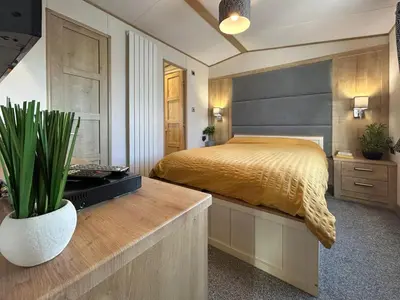 a bedroom with a bed and a desk with a plant at Millars Caravan in Ayr