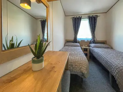 a room with two beds and a table with a potted plant at Millars Caravan in Ayr