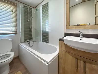 a bathroom with a tub and a sink and a toilet at Millars Caravan in Ayr