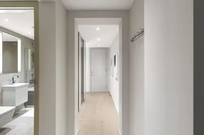 a hallway leading to a bathroom with white walls at Bright 3BR London Flat w Full Kitchen in Moffat