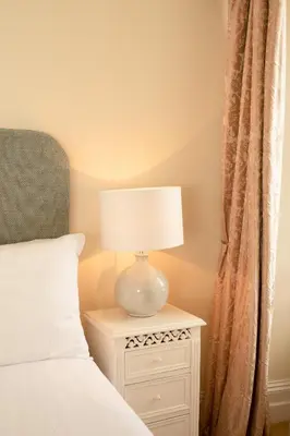 a lamp on a night stand next to a bed at Springkell in Eaglesfield