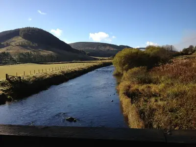 a river in a field with mountains in the background at Holiday Home Gehöft 2 by Interhome in Tweedsmuir