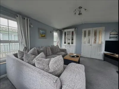 a living room with a couch and a tv at 'Sunset Lodge' Peaceful Coastal Retreat with Hot Tub in Monreith