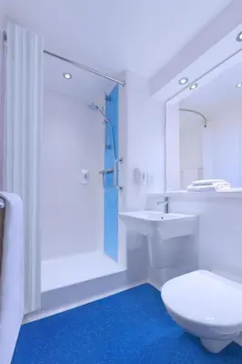 a white bathroom with a toilet and a sink at Travelodge Dumfries in Collin